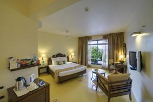 帕纳吉果阿皇冠酒店的酒店客房设有床和客厅。