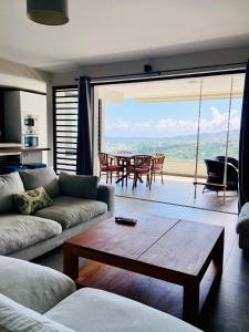 帕皮提Meherio - Bel Appartement vue mer à TAHITI的客厅配有沙发和桌子