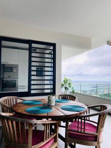 帕皮提Meherio - Bel Appartement vue mer à TAHITI的一间带木桌和椅子的用餐室
