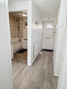 利兹2 Bedroom Cozy Chambers with free parking的浴室配有白色门和浴缸。