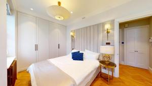 伦敦The Wimpole IX - 1 bed flat的卧室配有白色的床和桌子