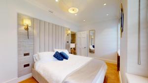 伦敦The Wimpole IX - 1 bed flat的卧室配有白色床和蓝色枕头