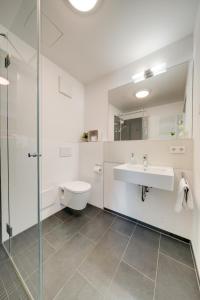 罗伊特林根☆Design Apartment Zentral☆200m vom Marktplatz☆ruhige Altstadtlage☆的浴室配有卫生间、盥洗盆和淋浴。