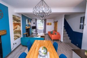 CymmerHappy Days Afan Forest的用餐室以及带桌子和蓝色墙壁的客厅。
