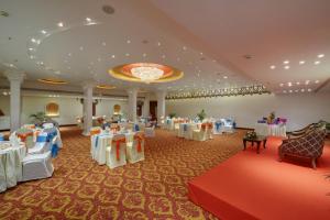 帕纳吉果阿皇冠酒店的宴会厅配有桌椅和吊灯