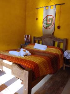 AicuñaHostal La Casa的卧室配有一张床,墙上挂着国旗