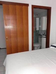 巴西利亚Sudoeste H215的一间带白色床的卧室和一间浴室