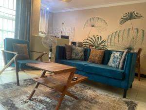 坎帕拉Barryston Haven 1的客厅配有蓝色的沙发和两把椅子