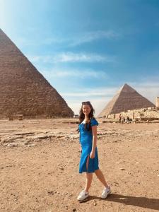 开罗Horus Pyramids Inn的站在金字塔前身穿蓝色衣服的女孩