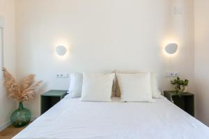 穆尔西亚La Casita del Malecón的卧室配有白色大床和白色枕头