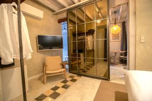 阿尔啼Blue Sardine Hostal Boutique Altea Adults Only的客房设有带椅子的玻璃衣柜和电视。