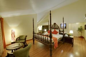 帕纳吉果阿皇冠酒店的卧室配有一张床和一张桌子及椅子