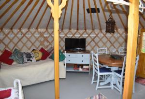彭赞斯The Yurt in Cornish woods a Glamping experience的蒙古包内带一张床和一张桌子的房间