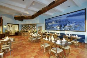 帕纳吉果阿皇冠酒店的一间带桌椅和大屏幕的餐厅