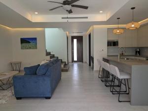 西湾Dolphin Villa #09的一间带蓝色沙发的客厅和一间厨房