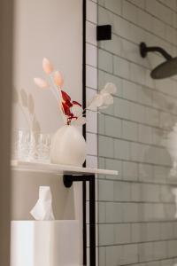 索诺玛埃多拉多酒店的浴室内一个白色花瓶,上面有鲜花