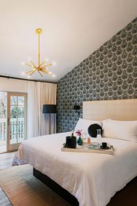 索诺玛埃多拉多酒店的卧室配有一张白色大床和一堵墙
