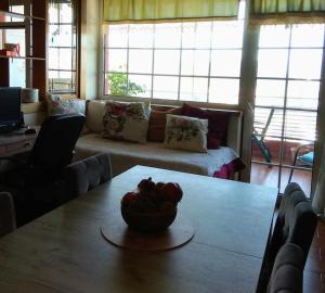 卡斯托里亚tania's view的客厅里设有一张桌子,上面放着一碗水果
