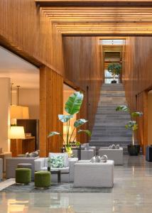 里斯本Inspira Liberdade Boutique Hotel的大堂配有沙发和植物,设有楼梯