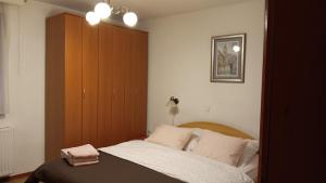拉夫纳格拉Apartment Medo的一间卧室配有一张床和一个木制橱柜