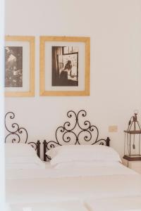 奥特朗托马赛利亚蒙特劳洛酒店的白色卧室的墙上挂有两张照片
