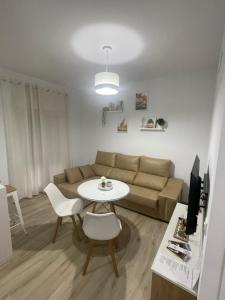 卡莫纳Apartamento Vitelio的客厅配有沙发和桌子