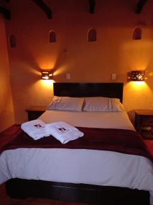 蒙圭Hotel Calicanto Real Cafe Museo的一间卧室配有一张床,上面有两条毛巾