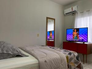 南雅拉瓜Quarto no Ap do Roberto Centro的一间卧室配有一张床和一台平面电视