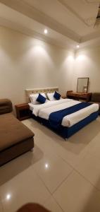 Ḩajlahالمبيت 4 للشقق الفندقيه的一间卧室配有一张大床和一张沙发