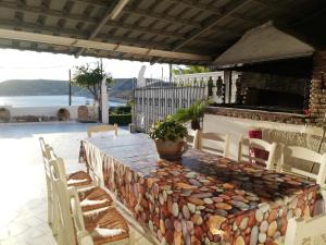 科洛皮奥Vaso' s Home的一个带石墙的庭院里的桌椅