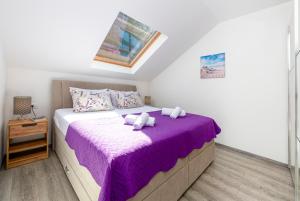 扎通Peaceful apartment near the beach - Sole的一间卧室配有一张带紫色毯子的床