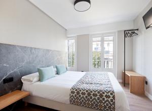 圣地亚哥－德孔波斯特拉PR 25 德胡里奥酒店的卧室配有带蓝色枕头的大型白色床