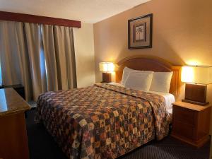福乐顿市格兰德旅馆的酒店客房,配有一张床和两盏灯