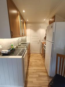 克里斯蒂安桑Guest house close to Kristiansand的厨房配有水槽和白色冰箱
