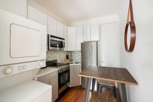 纽约24-4 New Private Terrace W D Apt Prime Gramercy的厨房配有白色橱柜和木桌