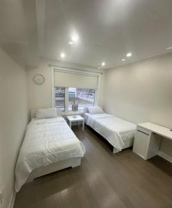 米西索加Modern Luxury 3 bed rooms House in Toronto Mississauga的一间卧室设有两张床,墙上挂着一个时钟。
