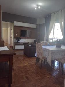 南卡希亚斯Apto central completo com garagem的客厅配有桌子和沙发