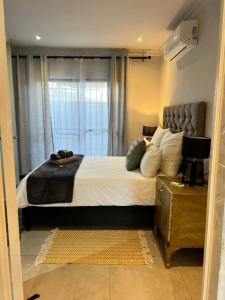 开普敦G’s Self Catering Apartments的一间卧室设有一张大床和一个窗户。