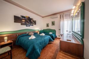陶尔米纳SUITE APARTMENT TAORMINA的配有绿床单的客房内的两张床