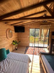瓜塔佩Cardinal Glamping的一间卧室设有一张床和一个大窗户