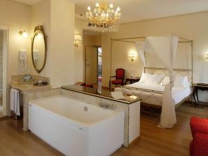 阿西西吉欧托温泉酒店的带浴缸和床的大型浴室