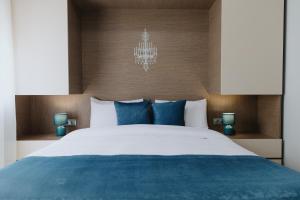 亚历山德鲁波利斯Faros Flat的卧室配有带蓝色枕头的大型白色床