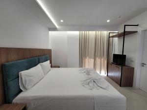 卡萨米尔Prestige Hotel的一间卧室配有一张床和一台电视