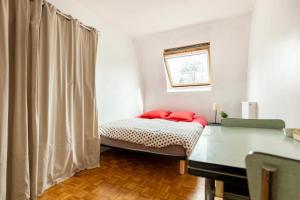 欧奈索斯博伊斯Chbre 2P + navette CDG的一间卧室配有一张带红色枕头的床