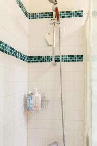 欧奈索斯博伊斯Chbre 2P + navette CDG的浴室铺有绿色和白色瓷砖,设有淋浴。