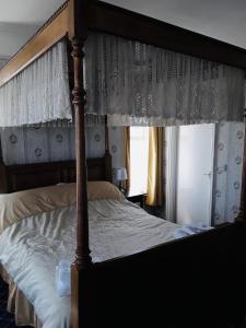 大雅茅斯Royal Hotel Great Yarmouth的一间卧室设有天蓬床和窗户。
