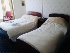 大雅茅斯Royal Hotel Great Yarmouth的酒店客房,配有两张床和椅子