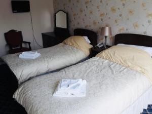 大雅茅斯Royal Hotel Great Yarmouth的配有两张床铺的酒店客房 - 带一双鞋