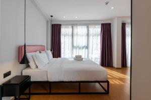 雅典PAREA Athens的卧室配有一张带红色窗帘的大型白色床