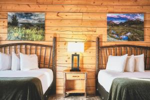 派恩代尔湖畔山林小屋度假酒店及码头的木墙客房的两张床